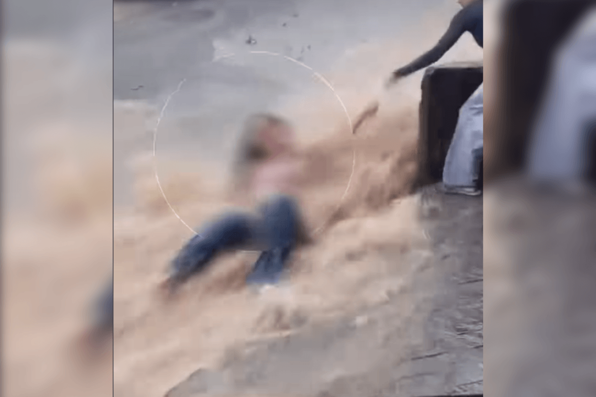 Jovem é resgatada após ser arrastada por enxurrada na rua e parar em poste