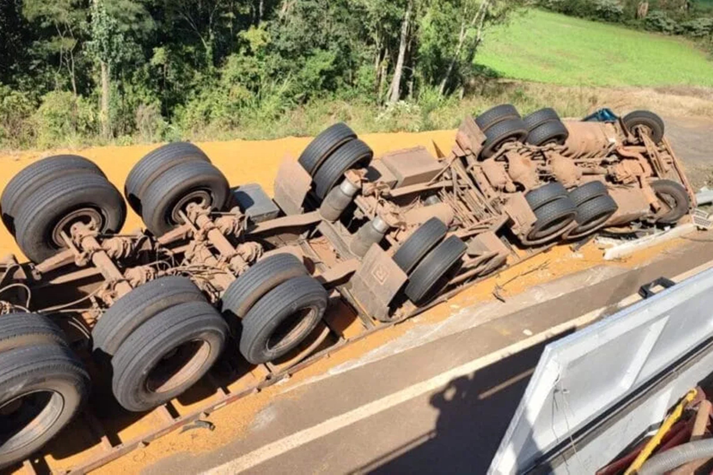 Esposa de caminhoneiro morre soterrada por carga em tombamento em SC